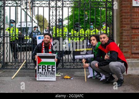 LONDON, ENGLAND - 15. Mai 2021: Demonstranten posieren mit einer verbrannten israelischen Flagge bei einem Marsch für Palästina-Demonstration Stockfoto