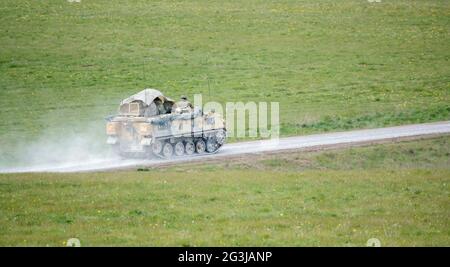 die britische Armee FV432 Bulldog, die auf einem Steinweg, voll beladen mit der Truppe bergens, unter einer Tarnplane rast Stockfoto