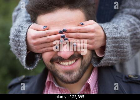 Frau schließt seinen Mann#39;s Augen Stockfoto