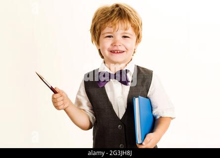 Schulzeit. Kleiner Junge mit Notizblock und Stift. Schuljunge. Bildung. Kind der Grundschule. Stockfoto