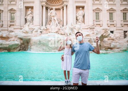 Vater und Tochter beim Brunnen Fontana di Trevi mit Münzen In Händen Stockfoto
