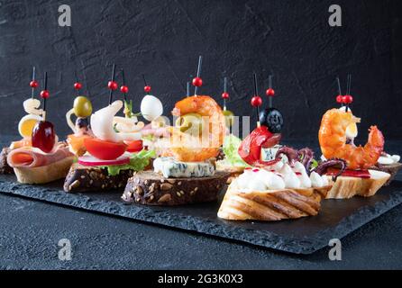 Die Tapas-Bar - ein traditioneller Snack in spanischer Küche, serviert mit Bier oder Wein - besteht aus Meeresfrüchten, Käse, Obst und h Stockfoto