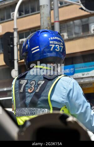 Medellin, Antioquia, Kolumbien. 11. Juni 2021. Verkehrspolizist mit seinem Rücken, der sich um ihn herum umsah. Stockfoto