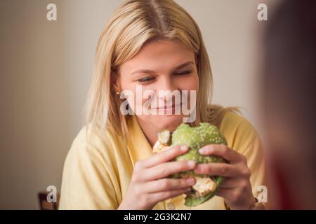 Frau im Restaurant vegane Burger Essen Stockfoto