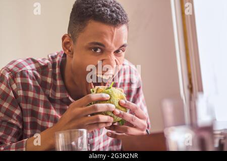 Mann isst Vegan Burger im restaurant Stockfoto