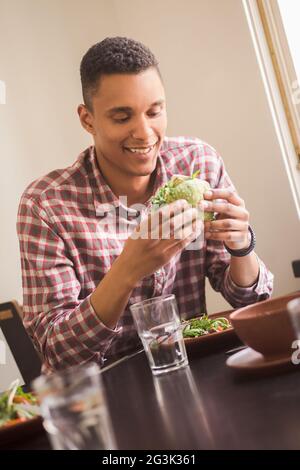 Mann isst Vegan Burger im restaurant Stockfoto