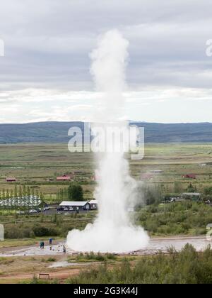 Beeindruckende Eruption des größten aktiven Geysir, Strokkur, mit Touristen warten herum, Golden Circle Stockfoto