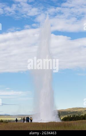 Beeindruckende Eruption des größten aktiven Geysir, Strokkur, mit Touristen warten herum, Golden Circle Stockfoto