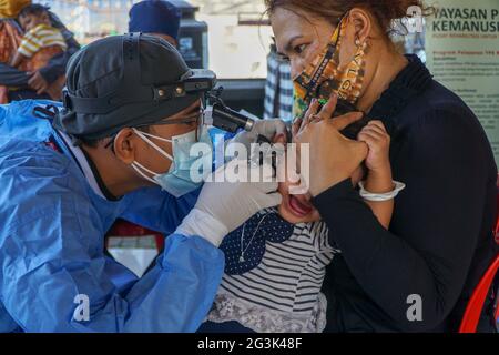 BALI/INDONESIEN-MAI 28 2021: Ein HNO-Arzt untersucht Ohren, Nase und Hals eines pädiatrischen Patienten. Während der COVID-19 Pandemie, HNO-Untersuchung Stockfoto