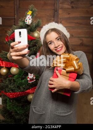 Schöne Mädchen, das Selfies in der Nähe von Neujahr Baum Stockfoto