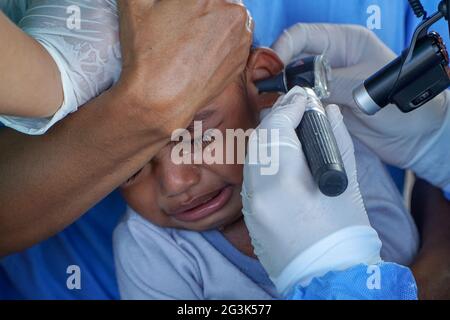 BALI/INDONESIEN-MAI 28 2021: Ein HNO-Arzt untersucht Ohren, Nase und Hals eines pädiatrischen Patienten. Während der COVID-19 Pandemie, HNO-Untersuchung Stockfoto