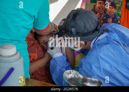 BALI/INDONESIEN-MAI 28 2021: Ein HNO-Arzt untersucht Ohren, Nase und Hals eines pädiatrischen Patienten. Während der COVID-19 Pandemie, HNO-Untersuchung Stockfoto