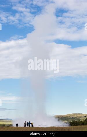 Beeindruckende Eruption des größten aktiven Geysir, Strokkur, mit Touristen warten herum, Golden Circle Stockfoto