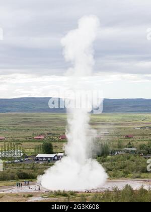 Beeindruckende Eruption des größten aktiven Geysir, Strokkur, mit Touristen warten herum, Golden Circle Stockfoto