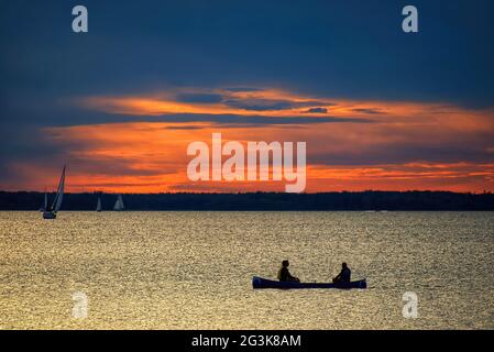 Sonnenuntergang über dem Ottawa River mit Kanu- und Segelbooten Stockfoto