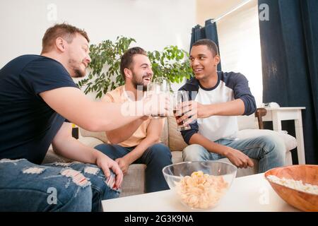 Glückliche Freunde trinken Bier zu Hause Stockfoto