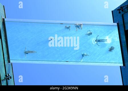 London, Großbritannien blickt auf den Transparent Sky Pool in Embassy Gardens, wo die Bewohner an einem sonnigen Tag in der Luft schwimmen. Stockfoto