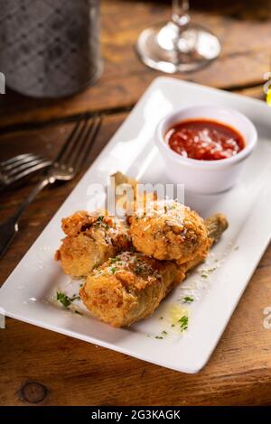 Gebratene Lammkoteletts in Parmesan-Teig mit Tomatensauce Stockfoto