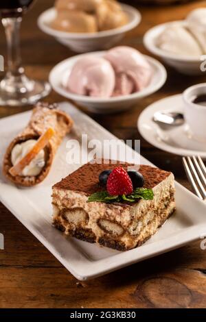 Traditionelle italienische Desserts, Tiramisu und Cannoli auf dem Teller Stockfoto