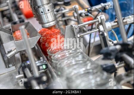 Maschine zum Befüllen von rotem Kaviar in Glasgefäße. Abfüllanlagen, Lebensmittelindustrie Stockfoto