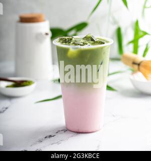 Kalter Matcha Latte in einem hohen Glas auf Marmor Stockfoto