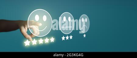 Ein Geschäftsmann bewertet mit einem Smiley-Face-Emoticon auf dem virtuellen Touchscreen, einer Umfrage zur Kundenzufriedenheit und einem Bewertungskonzept für den Kundenservice. Stockfoto