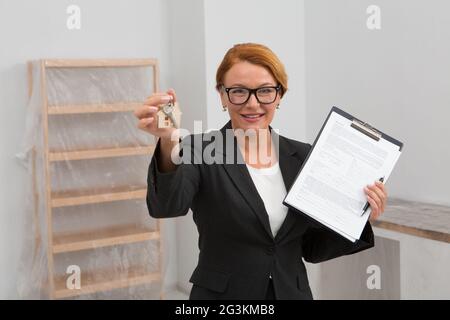 Grundstücksmakler schlägt vor, ein Abkommen über Wohnung mieten, Kamera auf Gesicht konzentriert. Stockfoto