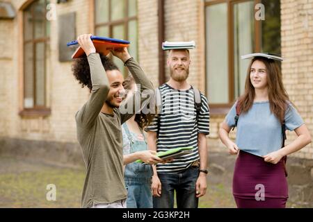 Schüler, Spaß, Bücher über Kopf halten. Stockfoto