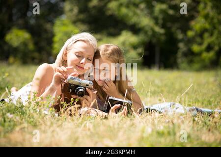 Mutter lehre Tochter, wie die Bilder auf der Kamera zu nehmen. Stockfoto