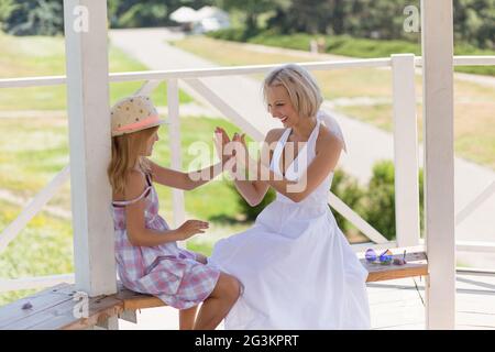 Schöne junge Mutter und Tochter spielen mit Händen. Stockfoto