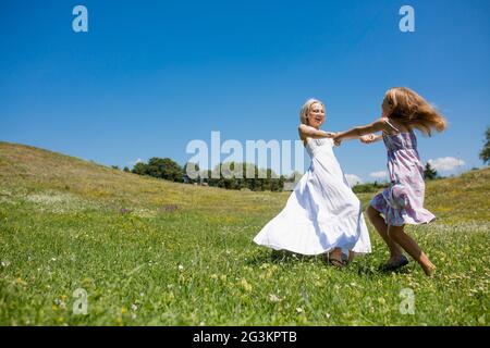 Mutter und Tochter happlly Spinnen halten sich an den Händen. Stockfoto