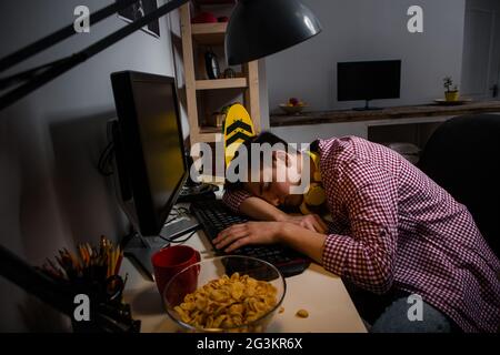 Teenager-Junge süchtig nach Computerspielen. Einschlafen vor dem Computer. Stockfoto