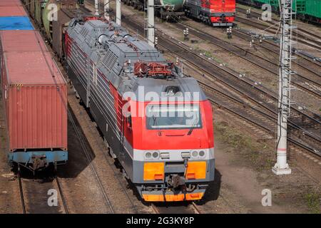 Die moderne rote Diesel-Elektrolokomotive ist an einem sonnigen Tag auf einer Eisenbahn Stockfoto