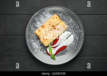 Ansicht von oben von dünnem Crepe mit Ricotta und Erdbeermarmelade auf einem Teller Stockfoto