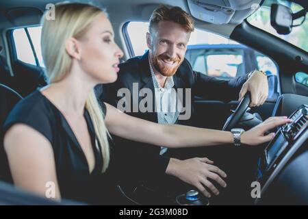 Hübsches Paar im Autosalon, das sich für ein Auto entschieden hat. Stockfoto