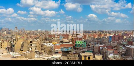 Panorama von schäbigen Gebäuden mit Satellitenschüsseln auf Dächern gegen blau bewölkten Himmel in der alten Stadt Kairo, Ägypten Stockfoto