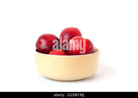 Reife rote Pfirsiche in einer Schale isoliert auf weiß. Nahaufnahme. Stockfoto