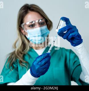 Arzt, Krankenschwester, Wissenschaftler Hand in blauen Handschuhen mit Grippe, Masern, Coronavirus, covid-19-Impfstoff-Krankheit Vorbereitung für Kind, Baby, Erwachsene, Mann und Wom Stockfoto