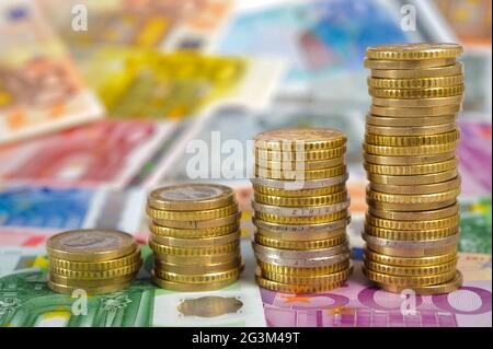 Euro-Banknoten und gestapelte Münzen Stockfoto