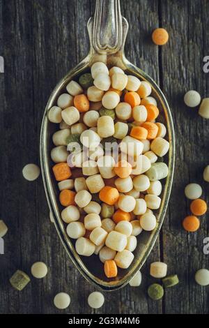 Löffel von rohen Couscous auf einer hölzernen Hintergrund Stockfoto