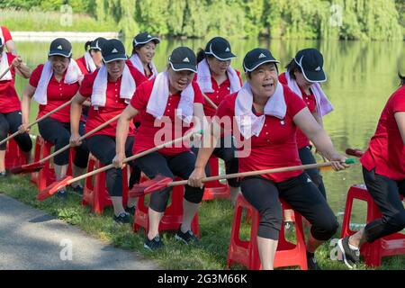 Chinesische amerikanische Tänzerin im mittleren Alter, die Künstler aufführt, probt eine Ruderübung in einem Park in Flushing, Queens, New York City Stockfoto