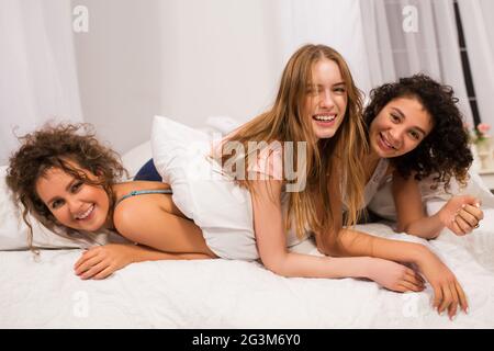 Mädchen im Bett mit Kissen kämpfen im Pyjama Stockfoto