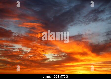 Sonnenuntergang am farbenfrohen, dramatischen Himmel mit roten und orangen Wolken. Malerische Landschaft als Hintergrund mit höllischen Farben Stockfoto