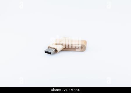 Holzstiftlaufwerk auf weißem Hintergrund, in einem stumpfem Winkel geöffnet, wobei der USB-Anschluss nach links zeigt. Stockfoto