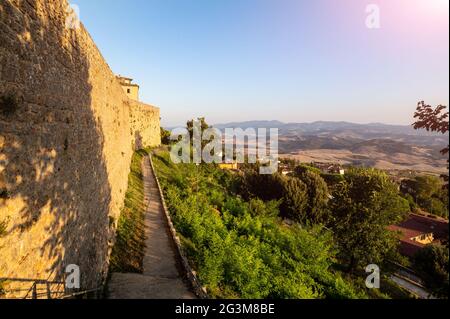 Volterra, Toskana, Italien. August 2020. Die Mauern des historischen Dorfes. Das warme Licht des späten Nachmittags verstärkt die massive Steinmauer an ihrer Stockfoto