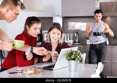 Junge Reisende mit Laptop planen touristische Reiseroute während des Frühstücks Stockfoto