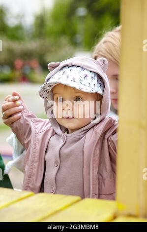 Mutter und Tochter auf dem Spielplatz im Freien. Gesunde Bewegung für Kinder. Kleine Mädchen und Mutter haben eine gute Zeit Stockfoto