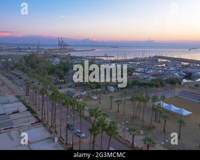 Top Luftaufnahme mit Blick auf den schönen Morgen an Finikoudes Palmenpromenade, Pier mit Yachten in der Nähe des Mittelmeers, und Volleyballplatz. Stockfoto