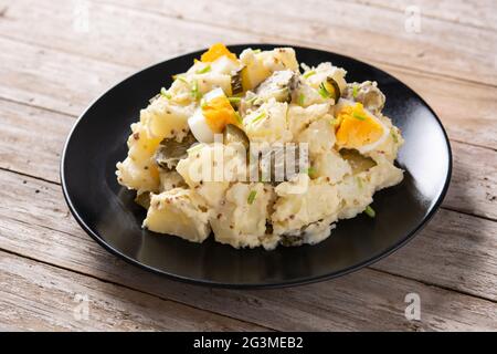 Kartoffelsalat mit Gurken, Ei und Senf auf Holztisch Stockfoto