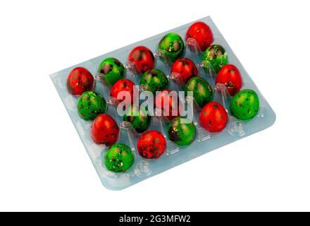 Box mit farbigen Wachteleiern isoliert auf weißem Hintergrund. Osterei von roter und grüner Farbe in einer blauen Verpackung. Osteressen. Stockfoto